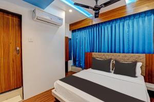 a bedroom with a bed with a blue curtain at Hotel Glaace Inn Near Delhi Airport in New Delhi
