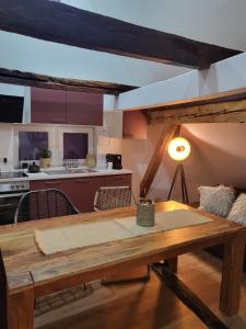 ein Wohnzimmer mit einem Holztisch und einer Küche in der Unterkunft Ferienwohnung im Rebstock Nr.1 in Bahlingen