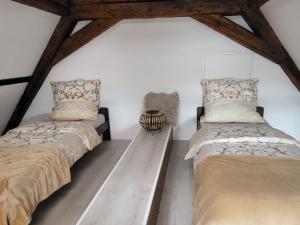 two beds in a room with white walls and wooden beams at Ferienwohnung im Rebstock Nr.1 in Bahlingen