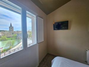 1 dormitorio con ventana y vistas a la ciudad en Hostal JP y Apartamentos, en Sangüesa