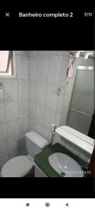 a bathroom with a toilet and a sink at Apartamento no Centro de Ubatuba in Ubatuba