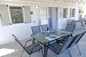 a dining room table with chairs and a bottle of wine at Sunset Beach House in Nea Potidaea