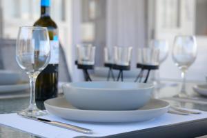 a table with a bowl and wine glasses on it at Sunset Beach House in Nea Potidaea