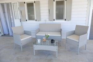 two chairs and a coffee table on a patio at Sunset Beach House in Nea Potidaea
