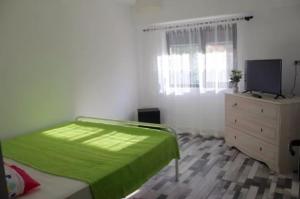 Un dormitorio con una cama, una cómoda y un televisor. en apartament Sara, en Mangalia