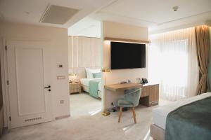 a bedroom with a desk and a bed and a television at Hotel Bernarda in Varaždinske Toplice