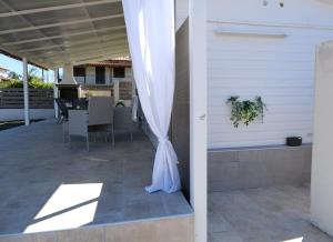 a white umbrella sitting on a patio at Sunset Beach House in Nea Potidaea +35 photos