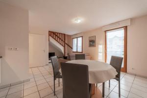 Mionnaz furnished flat في Epagny Metz-Tessy: غرفة طعام مع طاولة بيضاء وكراسي