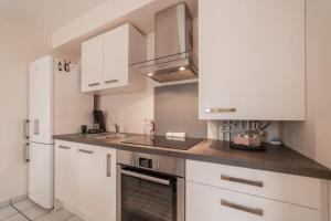 una cocina blanca con armarios blancos y fregadero en Mionnaz furnished flat en Epagny Metz-Tessy