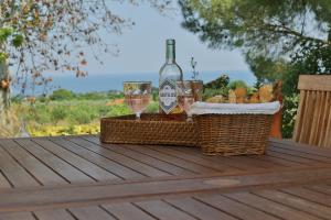 a basket of bread and wine glasses on a table at Οlives and Vines all seasons villa in Litochoro