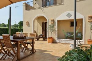 un patio esterno con tavolo e sedie in legno di Οlives and Vines all seasons villa a Litóchoron