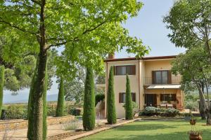 una vista exterior de una casa con árboles en Οlives and Vines all seasons villa en Litochoro