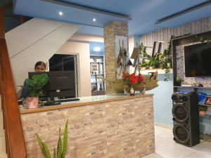 a woman standing behind a counter in a room at Isle inn {Fuvahmulah) in Fuvahmulah