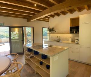 eine Küche mit weißen Schränken und einer Arbeitsplatte in der Unterkunft Casa Rural La Garza y la Paloma in Navaconcejo