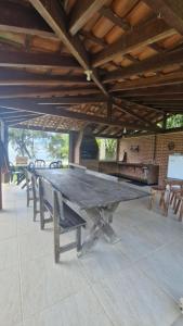 einen großen Holztisch in einem Zimmer mit Bänken in der Unterkunft Sítio Santa Cruz in Santa Cruz