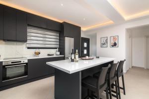 a kitchen with black cabinets and a white counter top at Mare Vento II in Zakynthos