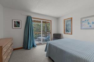 a bedroom with a bed and a sliding glass door at 4670 - Shell-Y-Bration by Resort Realty in Southern Shores