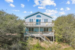 a house with a deck on the beach at 4670 - Shell-Y-Bration by Resort Realty in Southern Shores