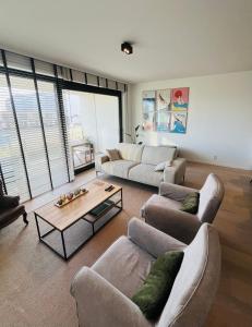 een woonkamer met banken en een salontafel bij Ruim en modern appartement ideaal gelegen tussen zee en jachthaven in Nieuwpoort