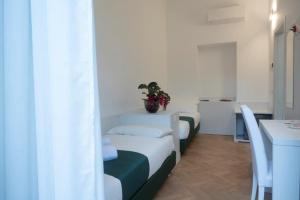 a room with two beds with a potted plant on it at B&B Emma in Rho