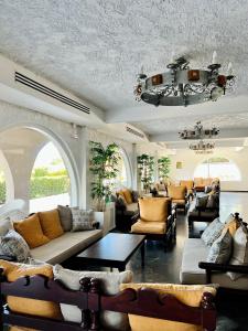 a large living room with couches and tables and windows at Karteros Hotel in Karteros