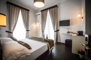 羅馬的住宿－聖彼得羅休閒豪華旅館，酒店客房设有一张床和两个窗户。