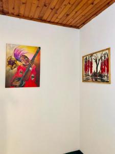 twee schilderijen aan een muur in een kamer bij COZY NYUMBA in Arusha