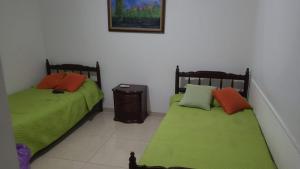 dos camas sentadas una al lado de la otra en una habitación en Habitaciones Festival Vallenato en Valledupar