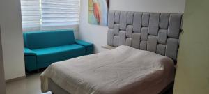 1 dormitorio con 1 cama y 1 silla azul en Habitaciones Festival Vallenato en Valledupar