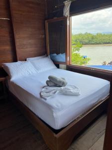 a bed on a boat with a view of the water at HOTEL RM in Nuquí