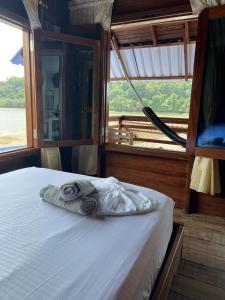 Una cama en un barco con toallas. en HOTEL RM en Nuquí