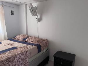 um pequeno quarto com uma cama e uma ventoinha em Apartamento en Cartagena em Cartagena das Índias