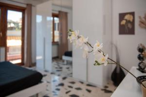 a vase with white flowers in a living room at Roma amoR Vitinia in Vitinia