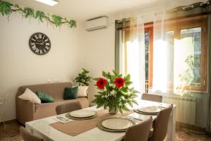 a living room with a table and a clock on the wall at Roma amoR Vitinia in Vitinia