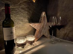 uma garrafa de vinho e copos de vinho numa mesa em Bear Hutte Saalbach near Billa em Saalbach-Hinterglemm