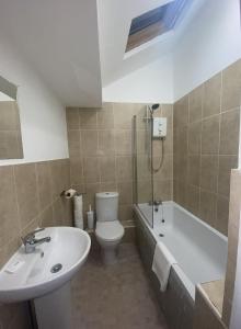 a bathroom with a sink and a toilet and a bath tub at Button Street by UStay Aparthotels in Liverpool