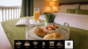 a tray with bread and a bowl of fruit and a glass of orange juice at Chalet Le Pélican in Lac-Superieur