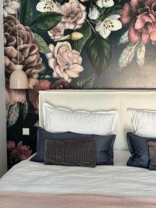 un dormitorio con una pintura de flores en la pared en Sievershof Poolloft, en Wietzendorf