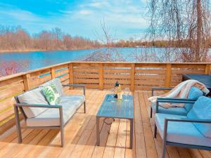 two chairs and a table on a deck with a view of a lake at Breezes Park in Acton