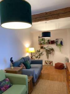 sala de estar con sofá azul y lámpara en La bergerie en Quillan