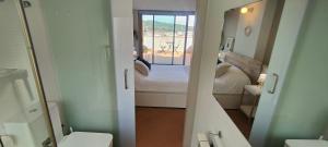 a bathroom with a bedroom with a bed and a mirror at Apartamento Loft Mar&Pol in Palafrugell +36 photos
