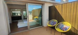a balcony with two yellow chairs and a bedroom at Apartamento Loft Mar&Pol in Palafrugell