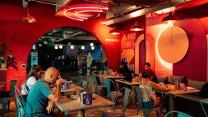 a group of people sitting at tables in a restaurant at Viajero Medellin Hostel in Medellín