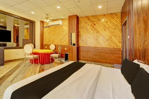 Schlafzimmer mit einem Bett, einem Schreibtisch und einem Tisch in der Unterkunft Galaxy Stay Hotel Near Delhi Airport in Neu-Delhi