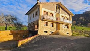 a building with a balcony on the side of it at Casa Rural Simonan Borda in Oiartzun