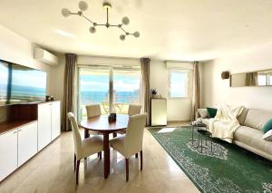 uma sala de estar com uma mesa de jantar e uma cozinha em Monte Carlo Vista - Vue Mer - Terrasse em Beausoleil