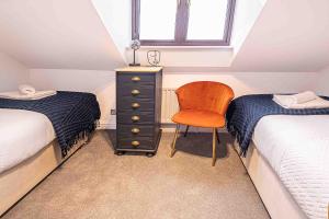 um quarto com 2 camas, uma cadeira e uma cómoda em Bright 2-bed Flat in Central Reading em Reading