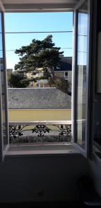 an open window with a view of a tree at Charmant studio le Crotoy in Le Crotoy +1 photo