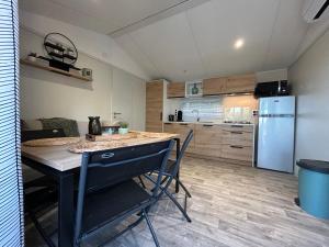 a kitchen with a table and chairs and a refrigerator at MOBIL HOME saint Raphael camping l’île d’or in Saint-Raphaël