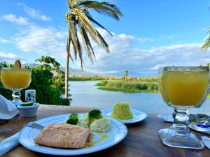 una mesa con comida y bebida y vistas al río en Hotel Boutique Punta Jamaica en Acapulco